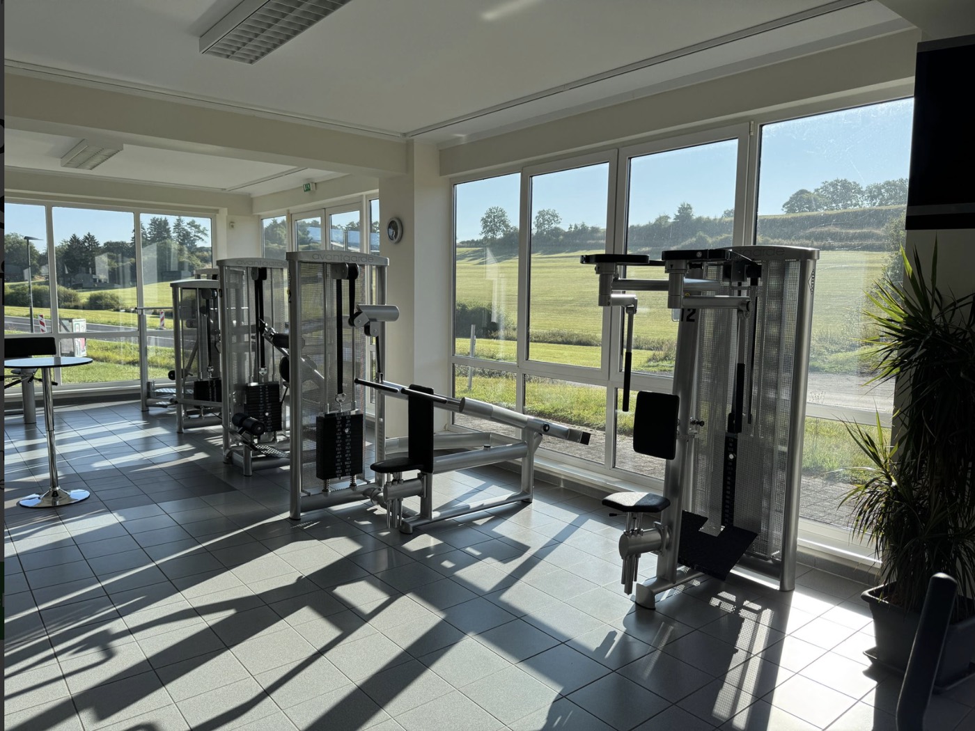 Heller Trainingsraum mit modernen Kraftgeräten und Panoramafenstern im Gesundheitszentrum Vitalzone Hillesheim in der Eifel
